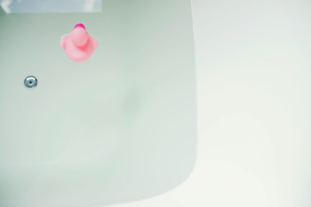 Bathtub with water and pink rubber duck