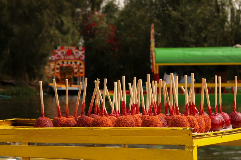 A large yellow tray of red candied apples. 