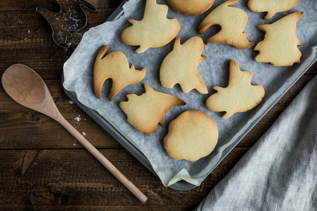 A tray of cookies shaped in a ghost, witch, cat, and skeleton for Halloween